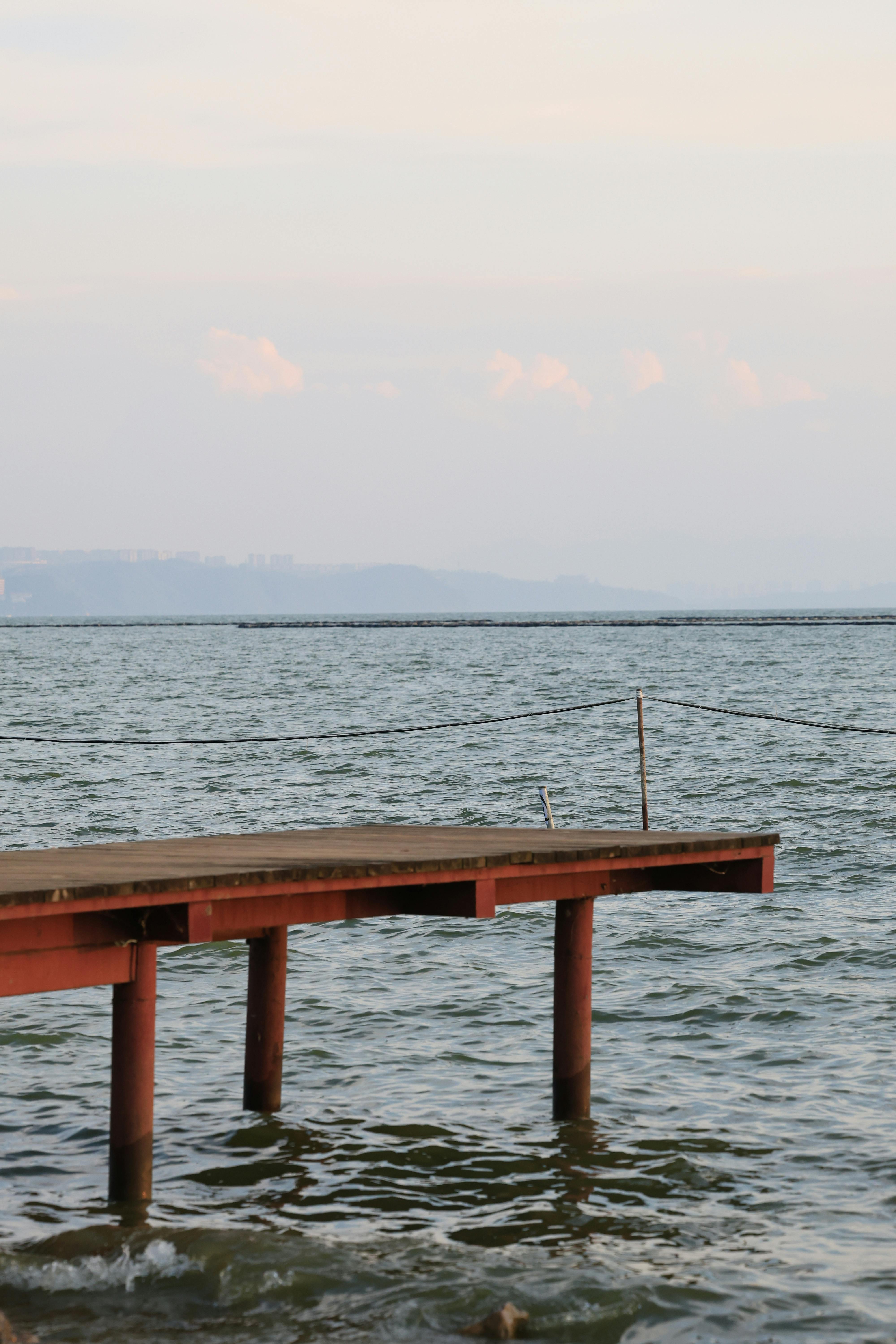 lonely pier extending into calm sea waters