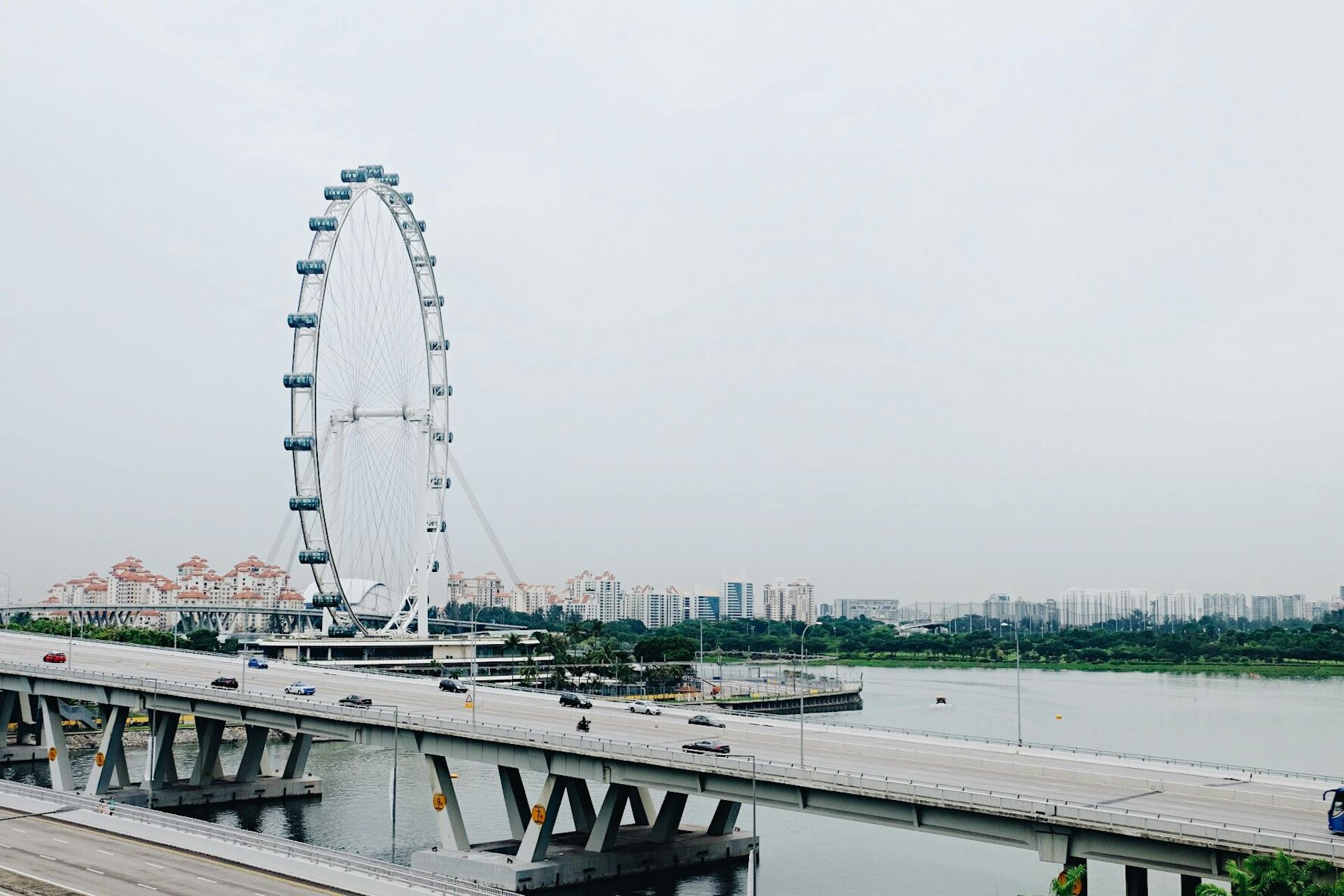 View of the Singapore Flyer, city skyline, and a busy bridge on a clear day.
