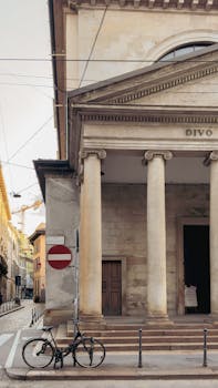 Explore the classic architecture of Milan featuring ancient columns and a vintage street scene.