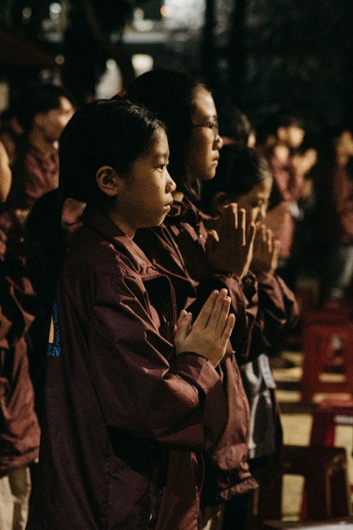 Free Teenagers engaged in a focused prayer ceremony outdoors at night. Stock Photo