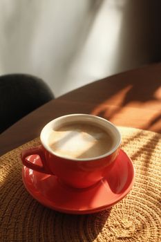 Warm morning light casts shadows over a coffee cup in a Montreal cafe.