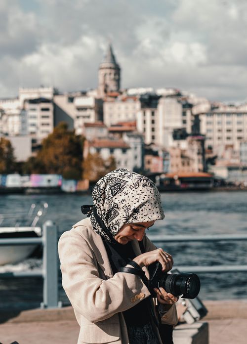 Free A woman takes photos near the iconic Galata Tower in Istanbul during the day. Stock Photo