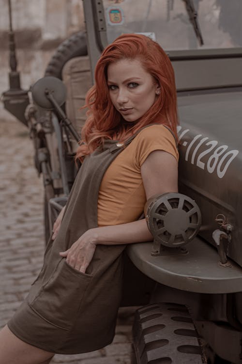 Photo of Woman Leaning on Military Vehicle Posing