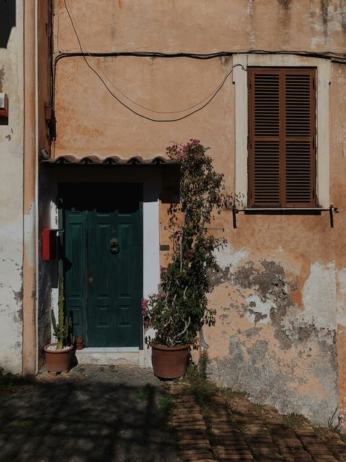 Free Rustic Italian facade with green door and plants in Rome, Italy. Stock Photo