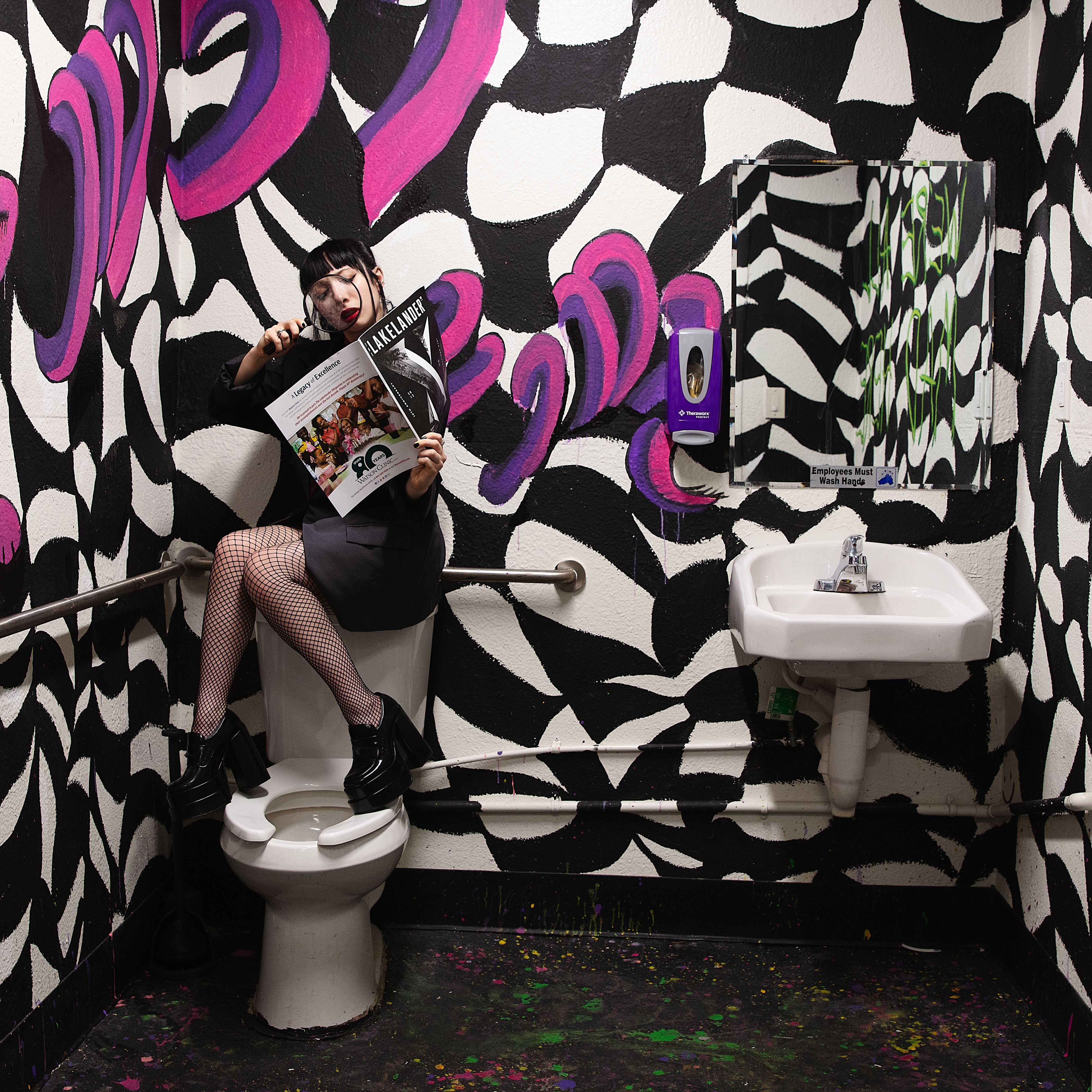 Free Woman reading magazine in a vibrantly painted restroom, blending ...