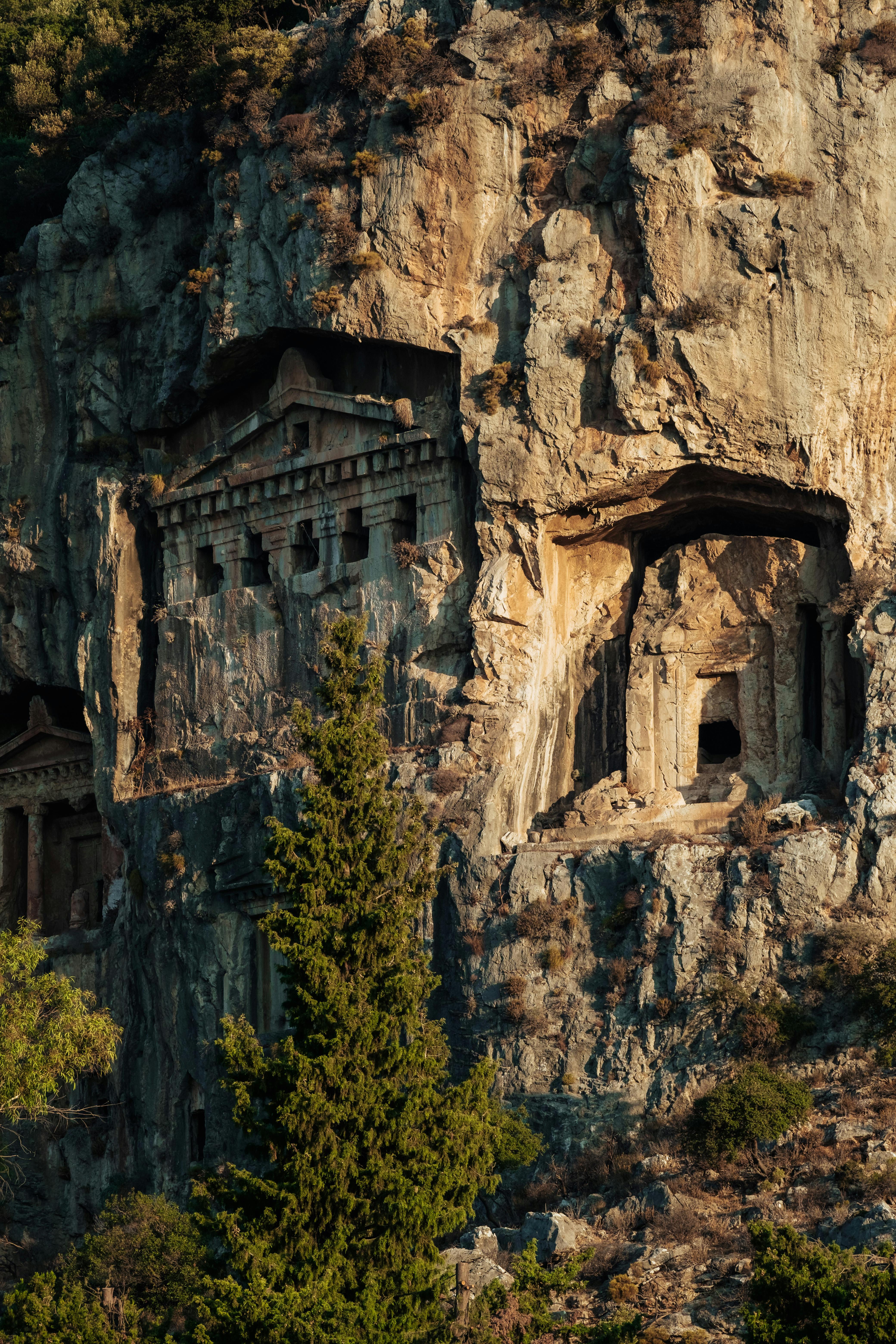 Stunning view of Dalyan's ancient Lycian rock tombs carved into cliffs, surrounded by lush greenery.