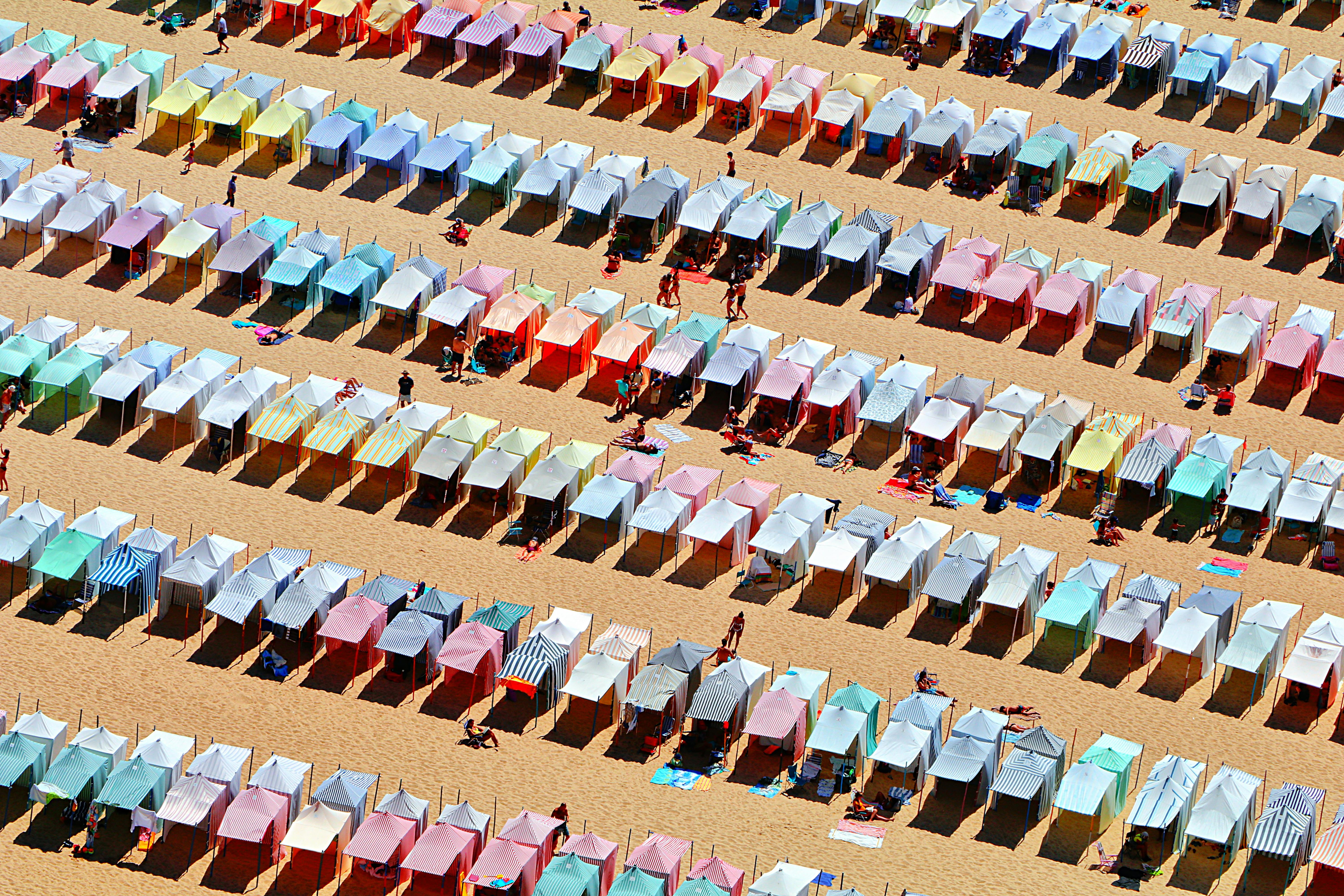Aerial view of vibrant beach tents in Nazaré, Portugal, capturing summer ambiance.