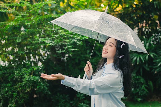 Young woman with umbrella feeling the rain in a lush green garden