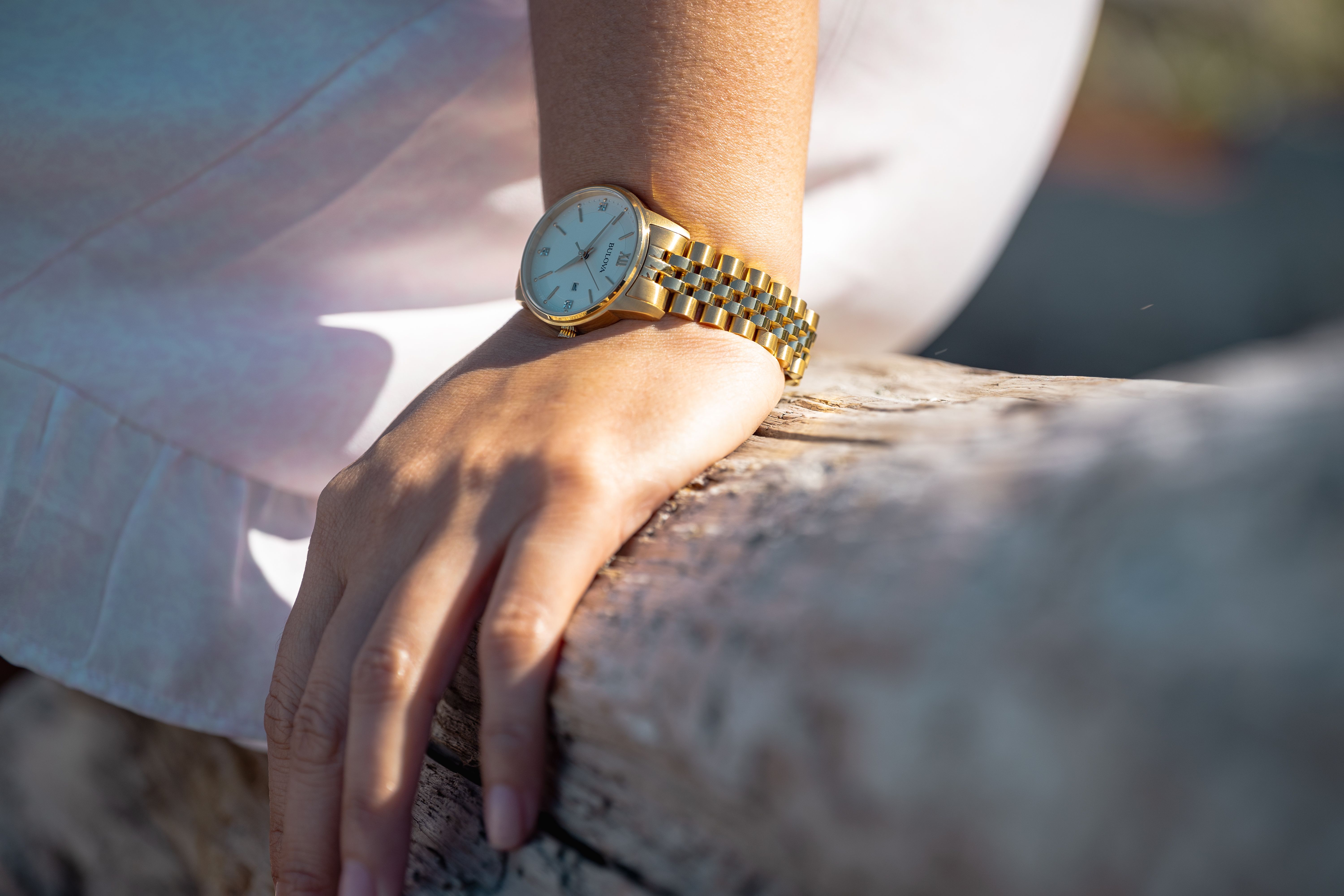 Elegant wristwatch on hand resting on wood · Free Stock Photo