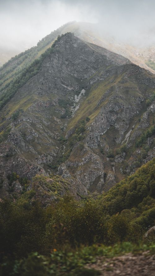 Free Explore the rugged beauty of a towering mountain peak enveloped in mist, showcasing nature's grandeur. Stock Photo