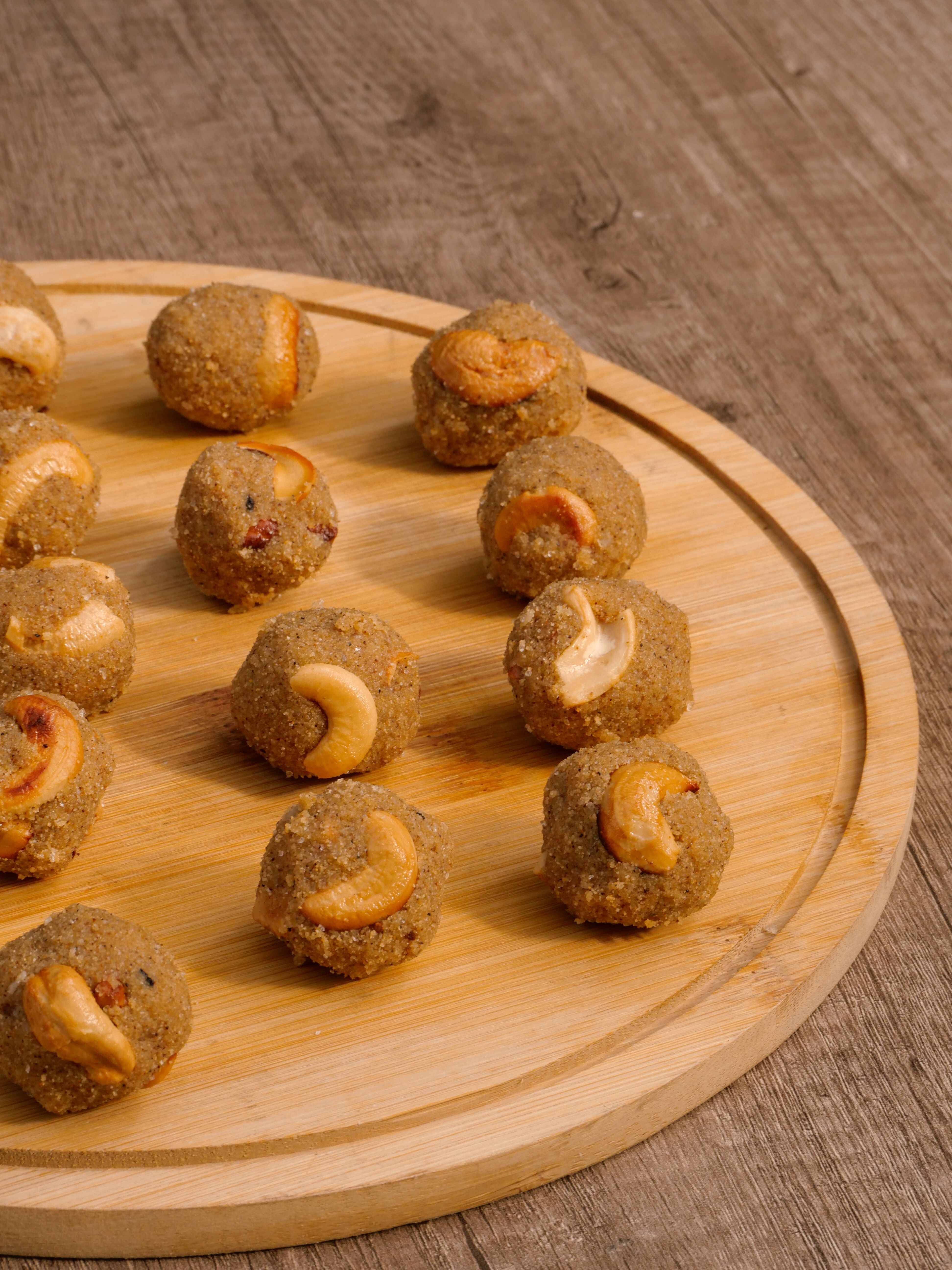 Freshly prepared Indian sweet ladoos garnished with cashews, perfect for festive occasions.