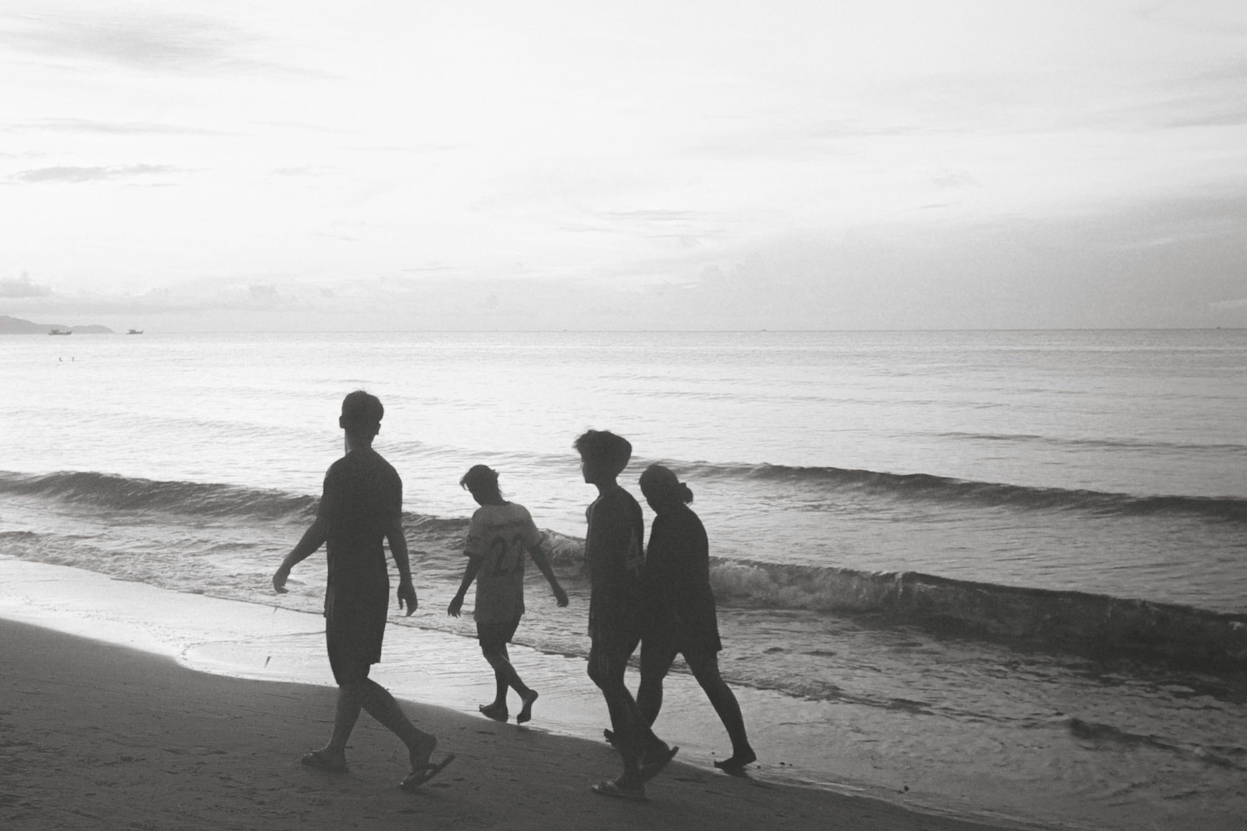 Silhouettes of People Walking Along the Beach · Free Stock Photo
