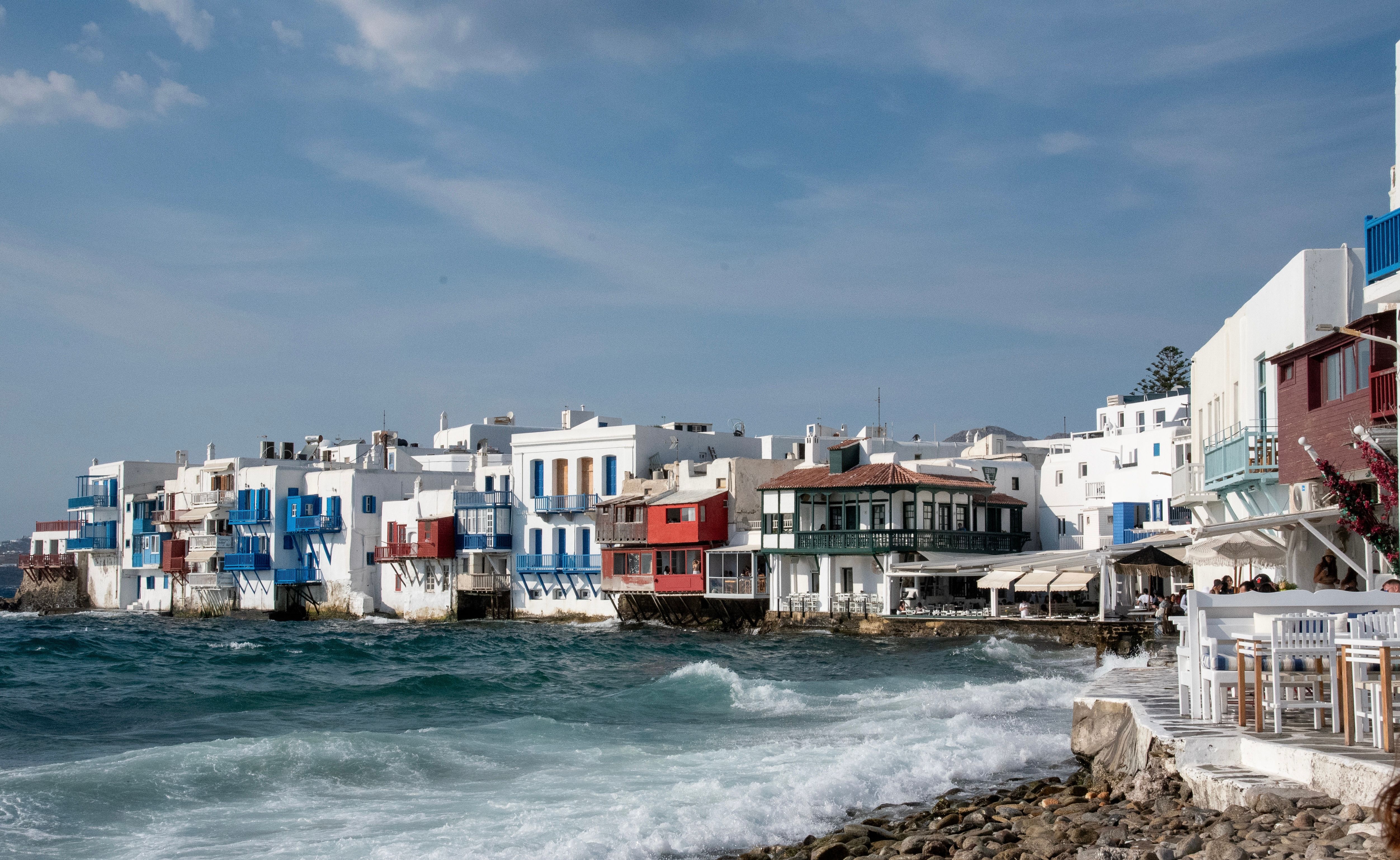 Charming coastal houses of Little Venice in Mykonos, Greece with vibrant colors and ocean waves.