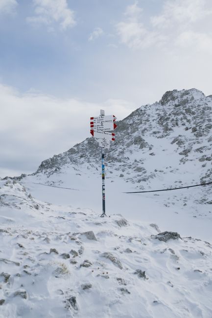 Snow-covered mountain path sign in San Martino di Castrozza, Dolomites, Italy.