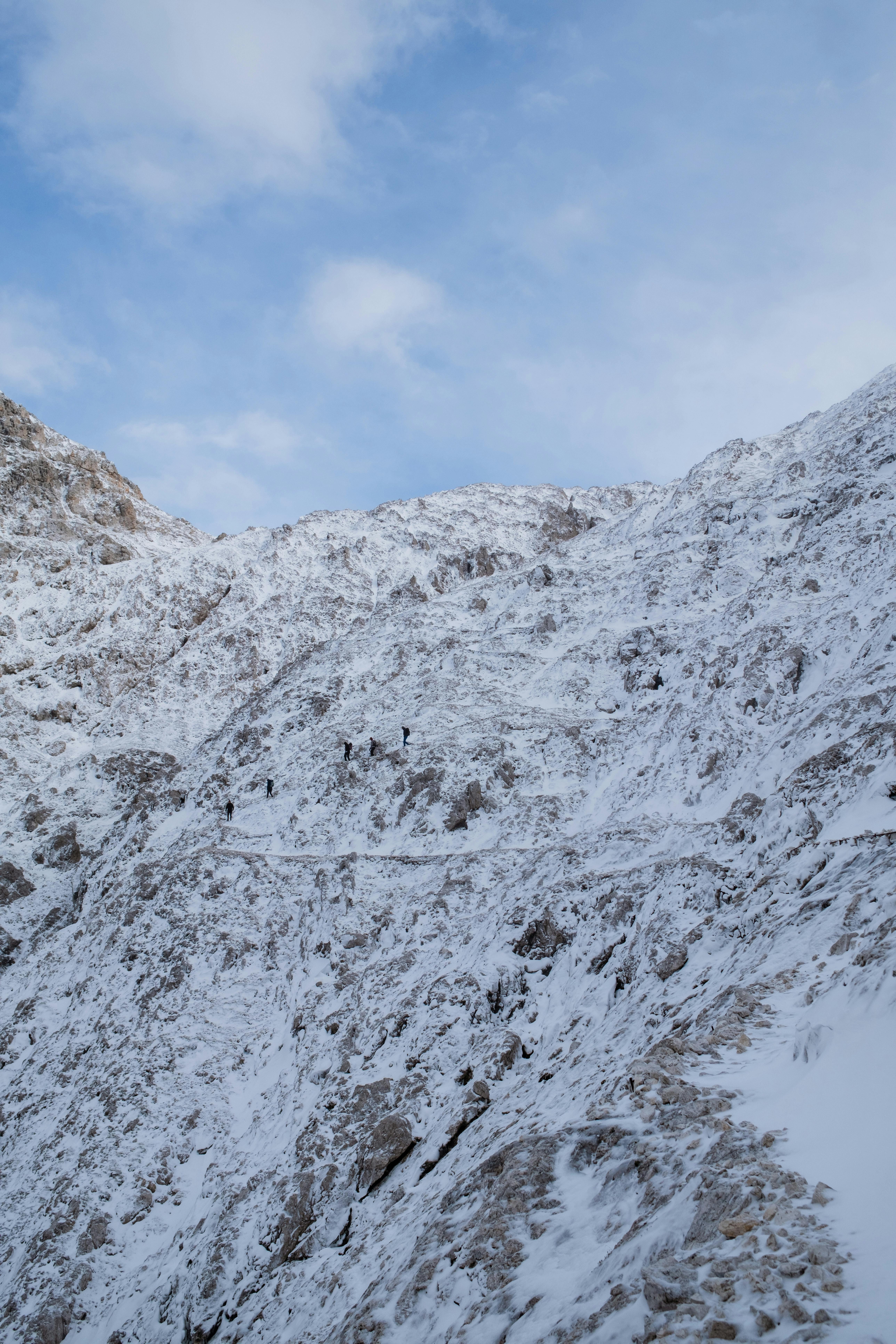 A serene snowy mountain in San Martino di Castrozza, Italy under a clear blue sky.