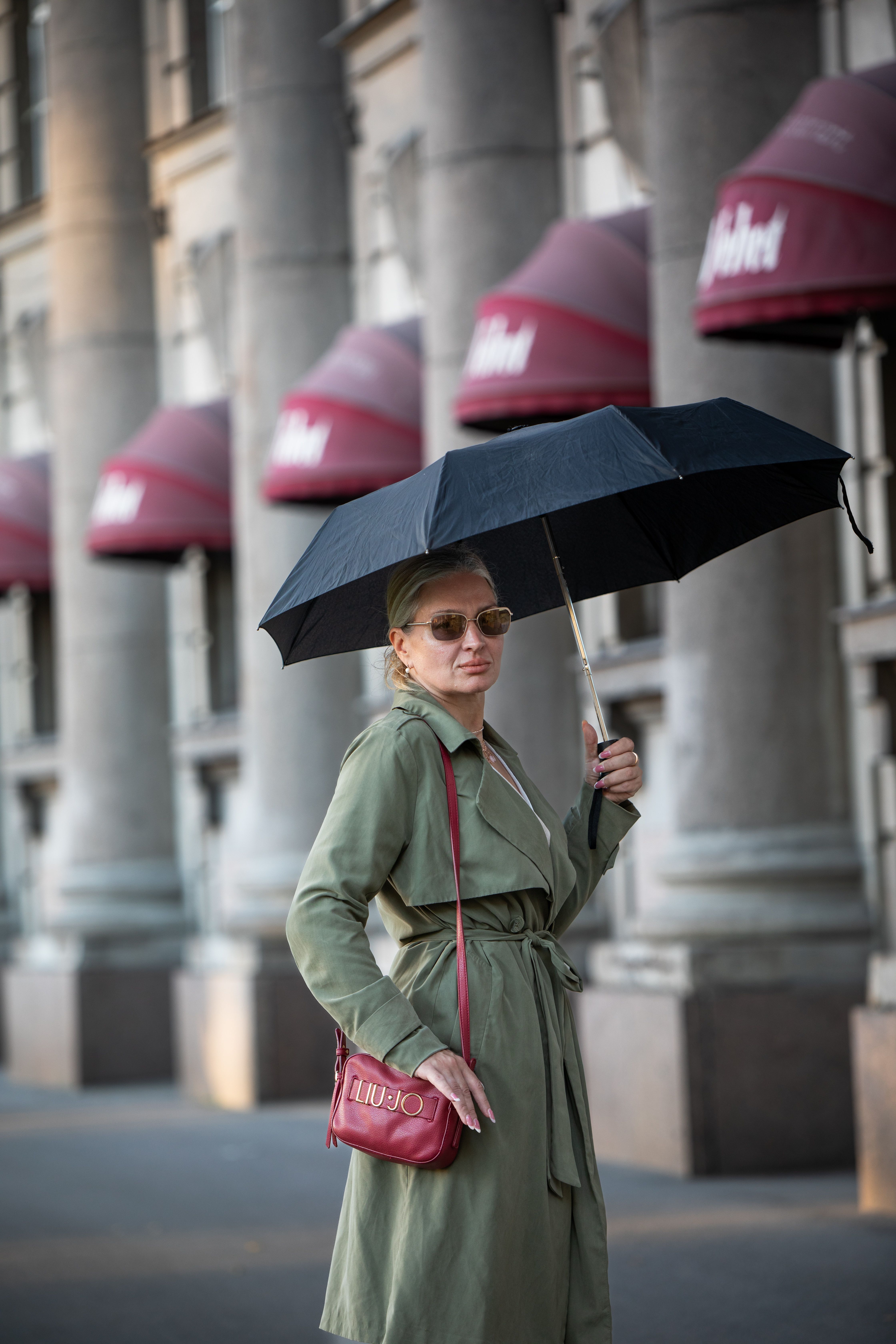 Woman in Trench Coat with Umbrella on City Street · Free Stock Photo