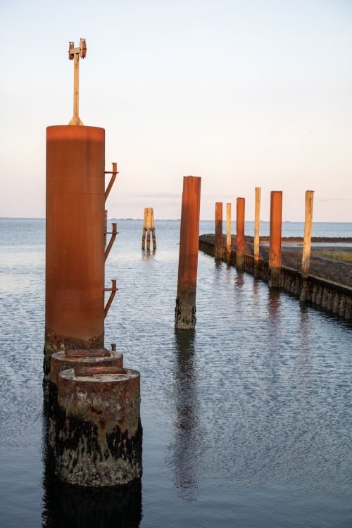 Free Rusty metal pilings in calm waters of the North Sea, Amrum, Germany. Stock Photo