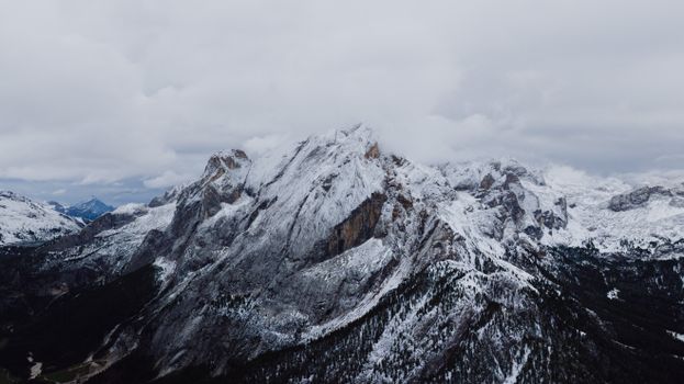 Breathtaking aerial view of the snow-covered Dolomite mountains in Canazei, Italy, captured in winter.
