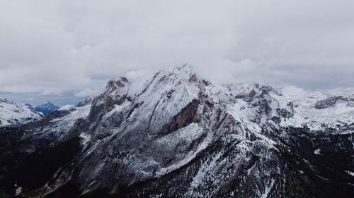 Free Breathtaking aerial view of the snow-covered Dolomite mountains in Canazei, Italy, captured in winter. Stock Photo