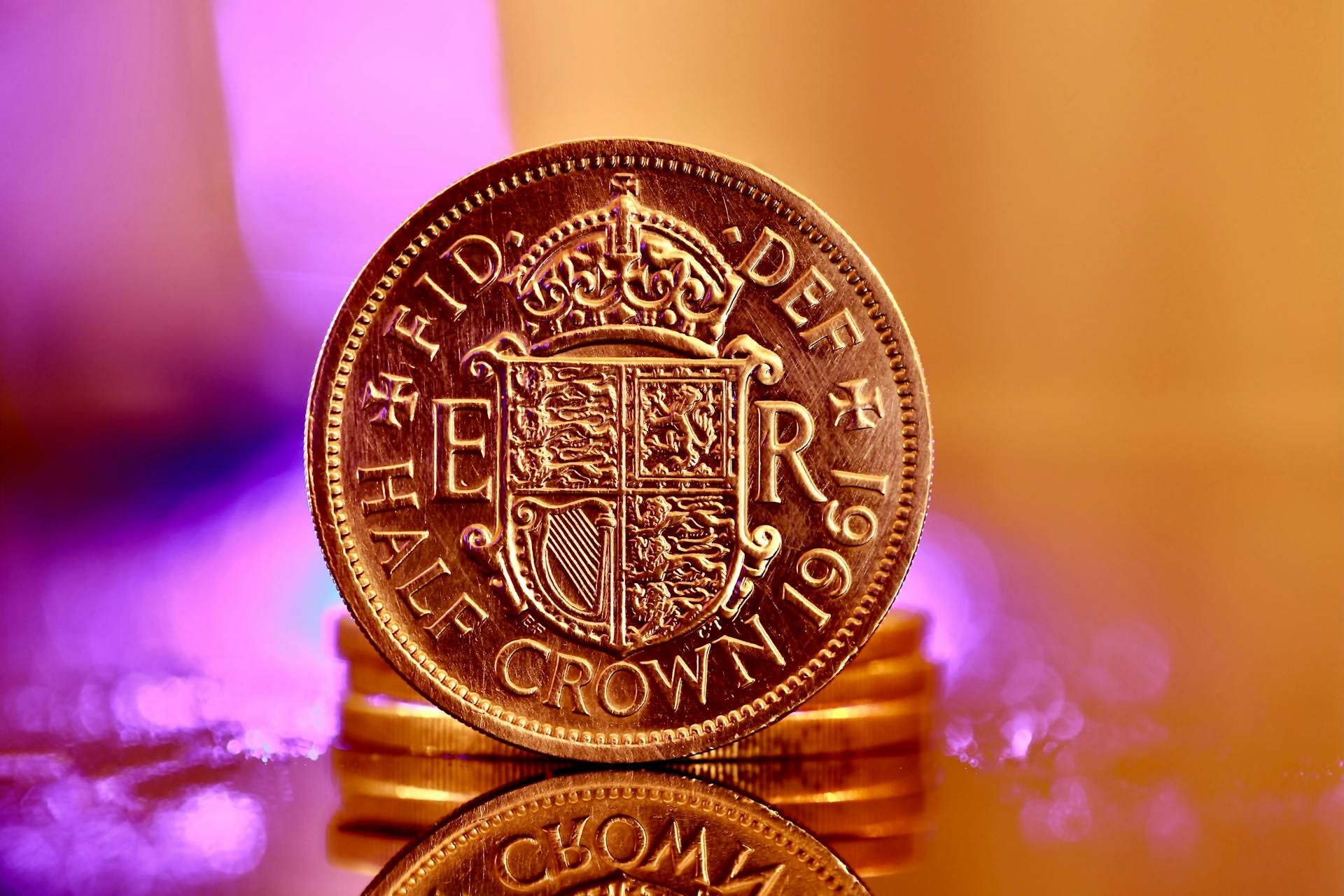 Detailed close-up of a vintage 1961 half crown coin with golden tones and purple bokeh background.