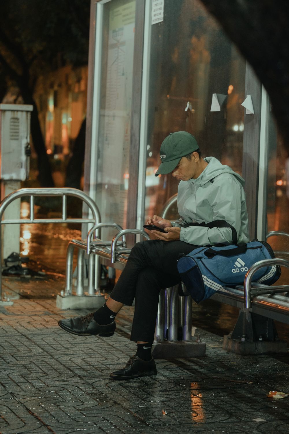 Man Waiting at Night Bus Stop with Rain · Free Stock Photo