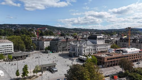 Free Stunning aerial view of Zürich's Opera House, surrounded by urban architecture and lush greenery. Stock Photo