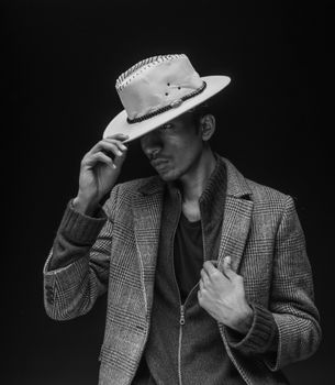 Black and white portrait of a man in a hat exuding style and elegance.