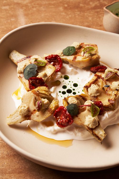 Free A gourmet dish featuring grilled artichokes with creamy cheese and tomato toppings. Stock Photo