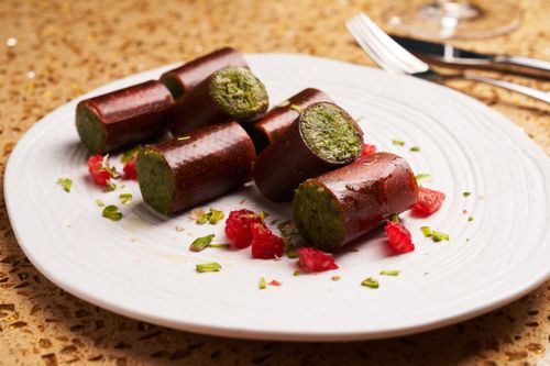 Free Elegant platter of gourmet sausages with a vibrant herbal filling and garnish. Stock Photo