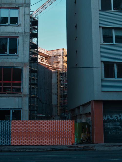 Free A modern construction site between two buildings in an urban setting. Stock Photo
