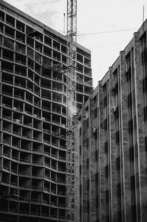 Free Monochrome image of two buildings with a crane, showcasing urban architecture. Stock Photo