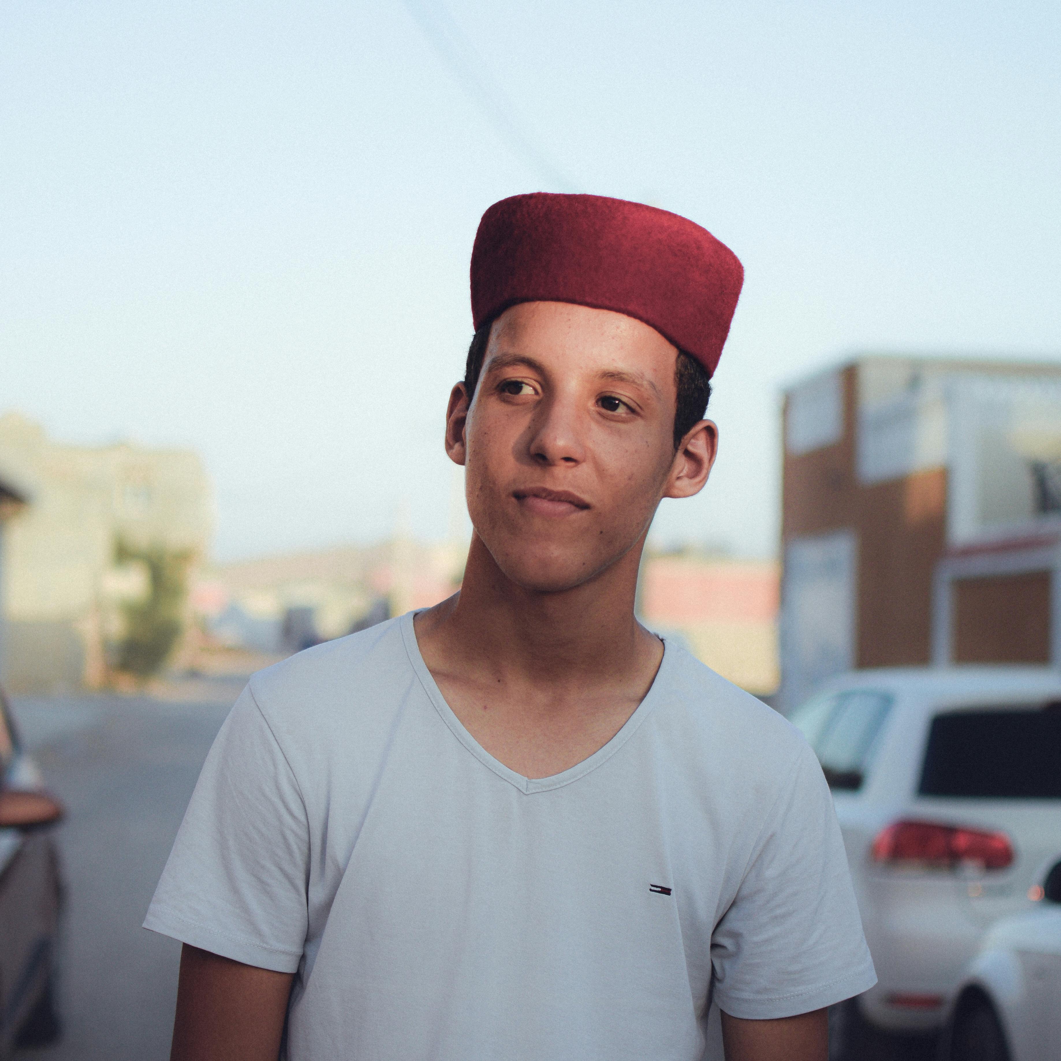 Portrait of a young man wearing a chechia in the streets of Tataouine, Tunisia.