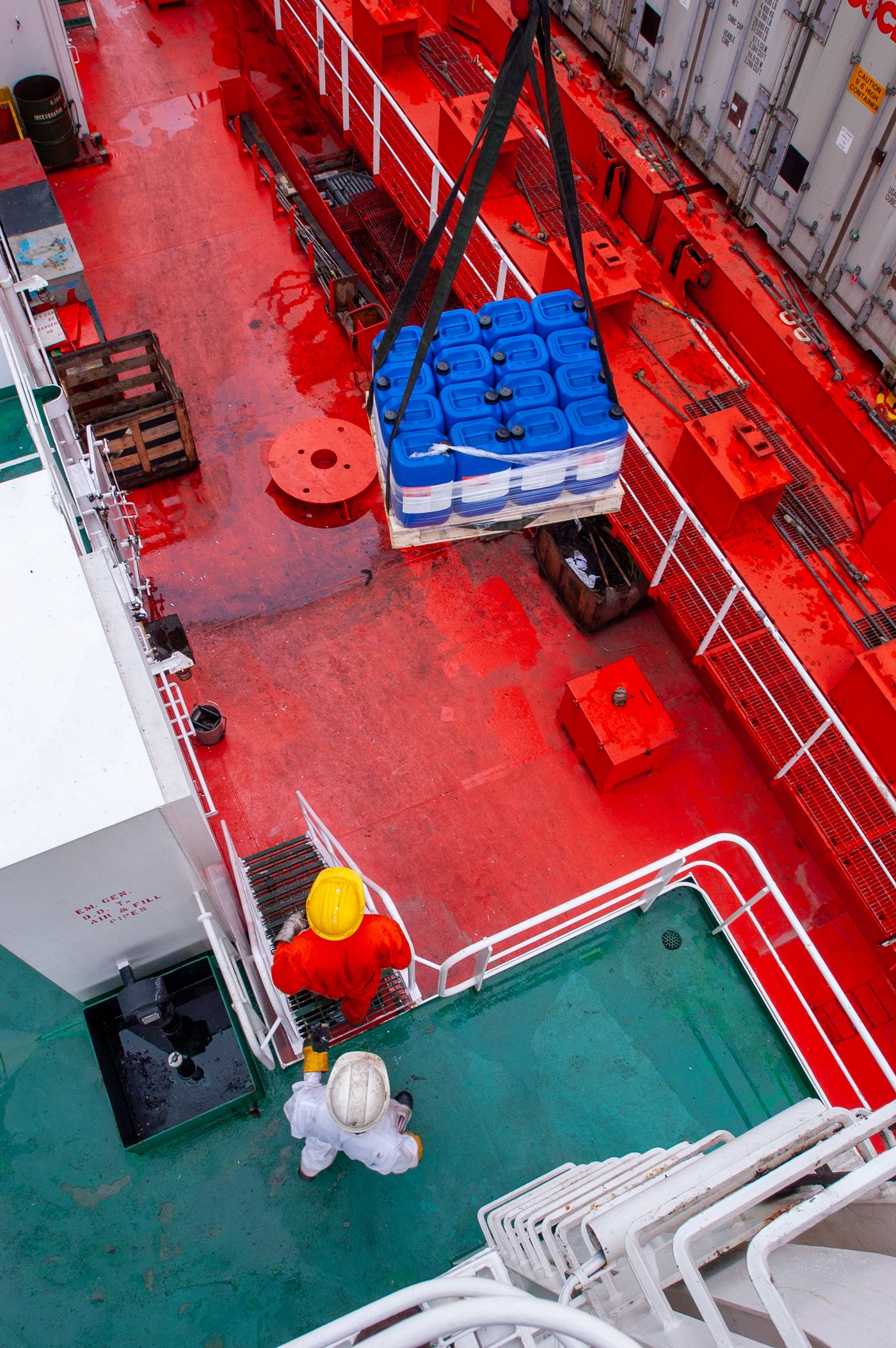 Workers loading supplies onto a ship deck