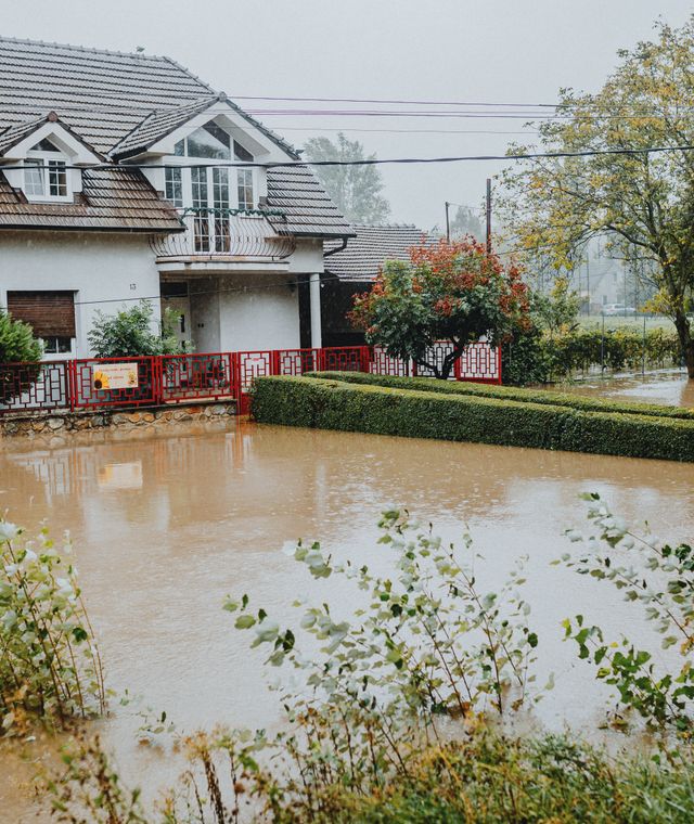 Suburban house surrounded by floodwater after heavy rain