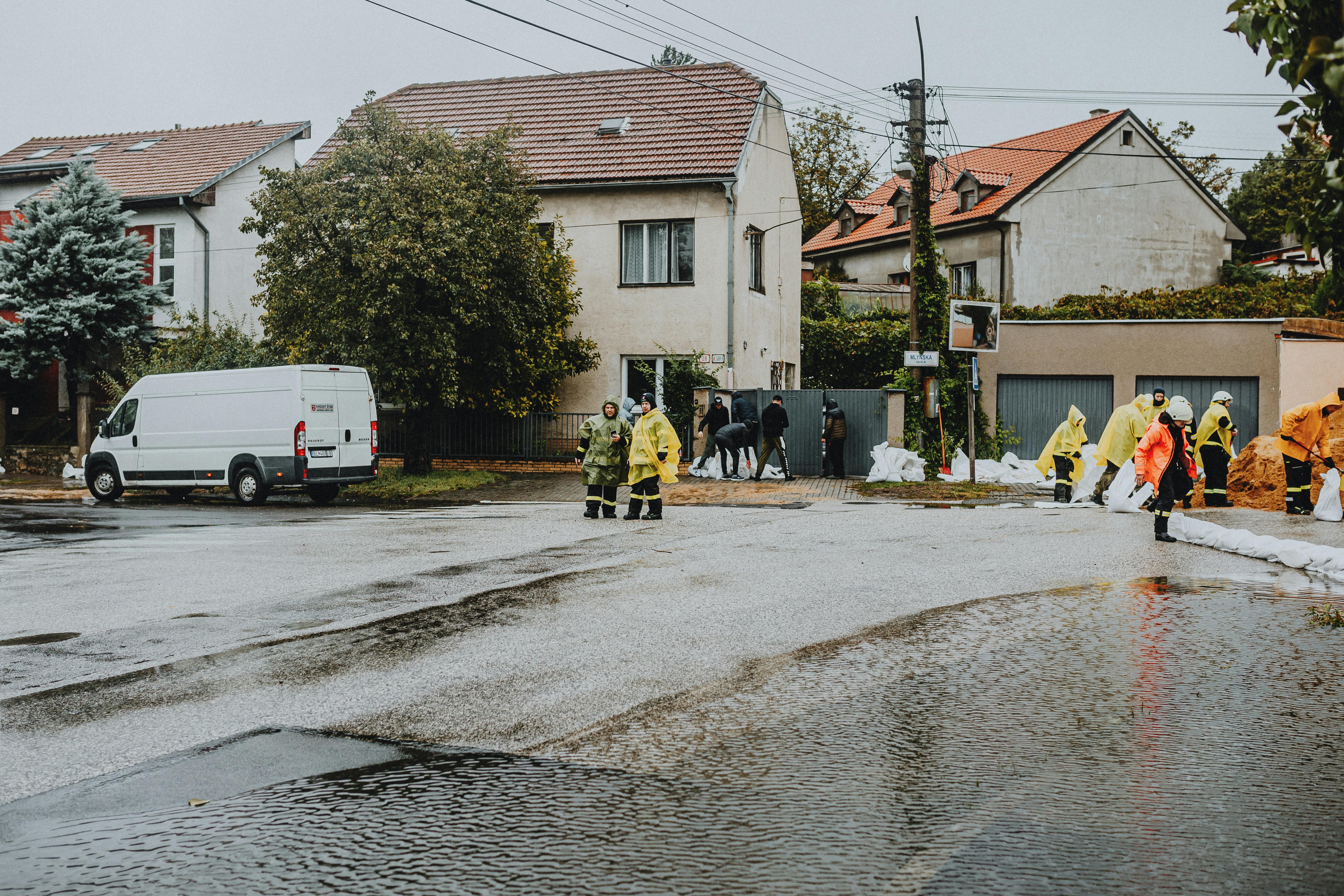 Emergency response team tackles flooding in a residential neighborhood with sandbags and preparation.