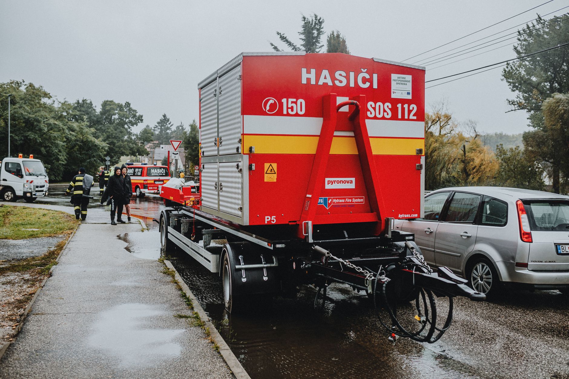 Fire department emergency vehicle stationed outdoors in rainy weather.