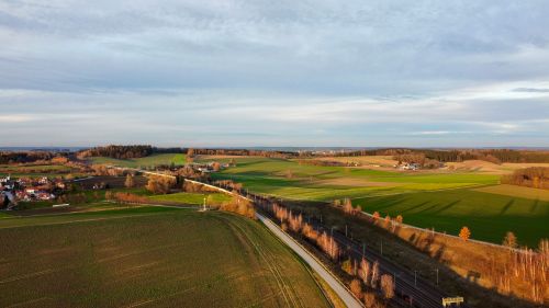 Free Aerial view over expansive autumn farmland with roads and fields under a cloudy sky. Stock Photo