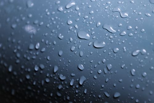 Free A close-up of water droplets on a smooth blue surface, capturing the beauty of nature. Stock Photo