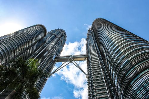 Free View of Petronas Twin Towers and Skybridge under blue sky in Kuala Lumpur. Stock Photo
