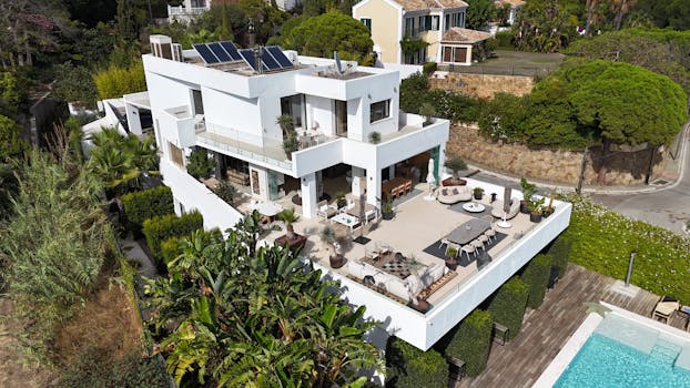 Aerial shot of a modern luxury villa with a spacious terrace and pool.