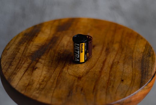 A Kodak Ultra film roll placed on a wooden surface, showcasing vintage photography.