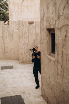 A photographer with a camera captures the rustic charm of old Dubai's architecture.