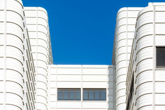 White modern building facade with clear blue sky in Den Haag, Netherlands.