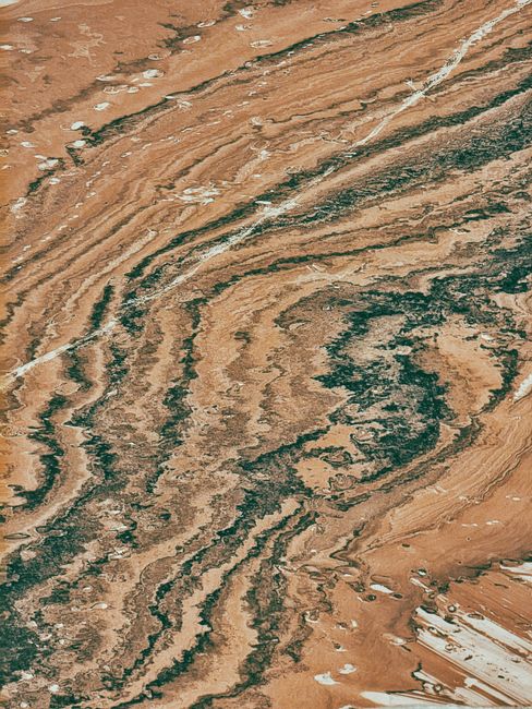 Aerial shot displaying an abstract, rugged view of desert-like terrain with natural formations.
