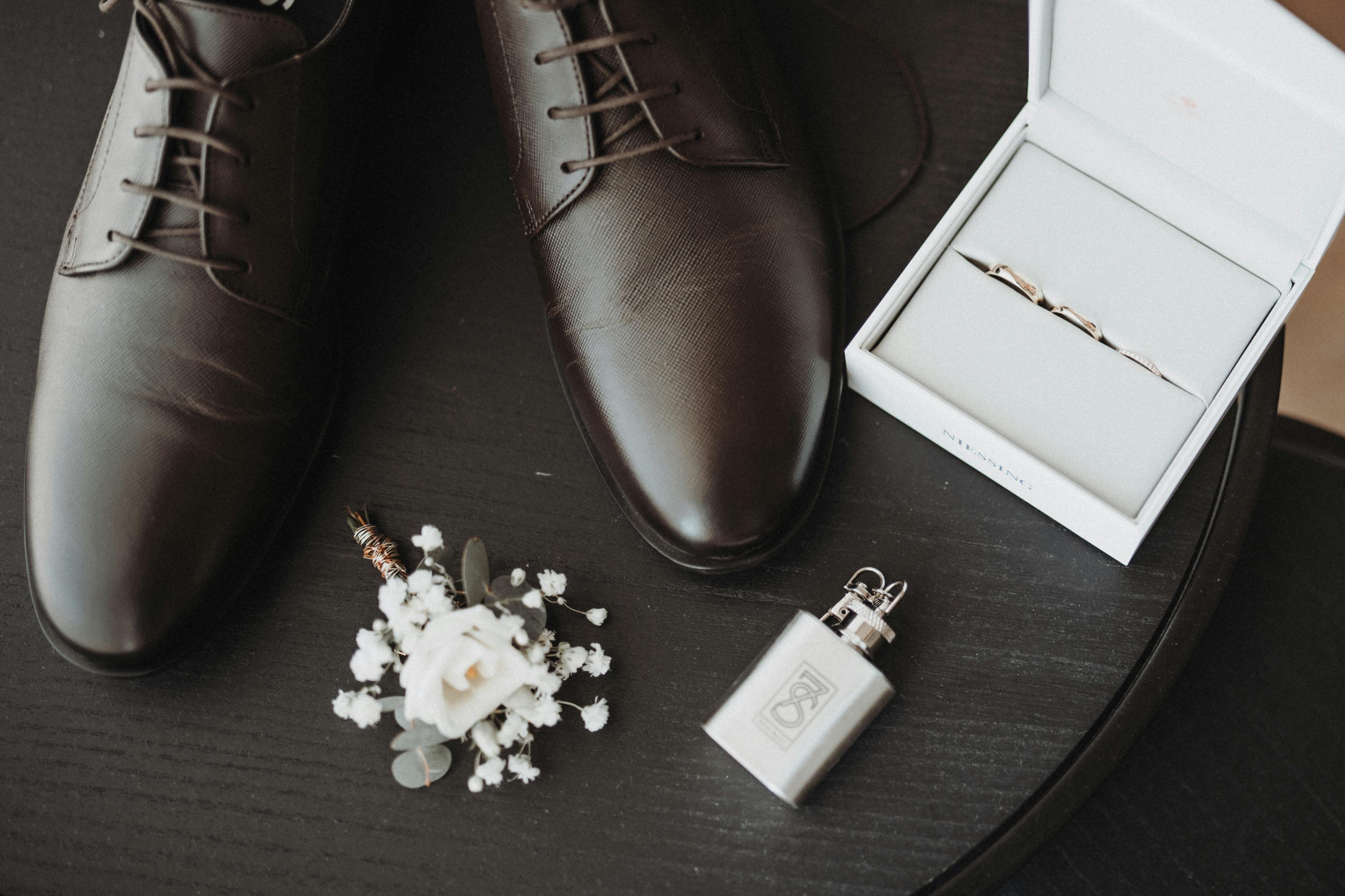 Stylish wedding accessories including shoes, boutonniere, and cufflinks on display.