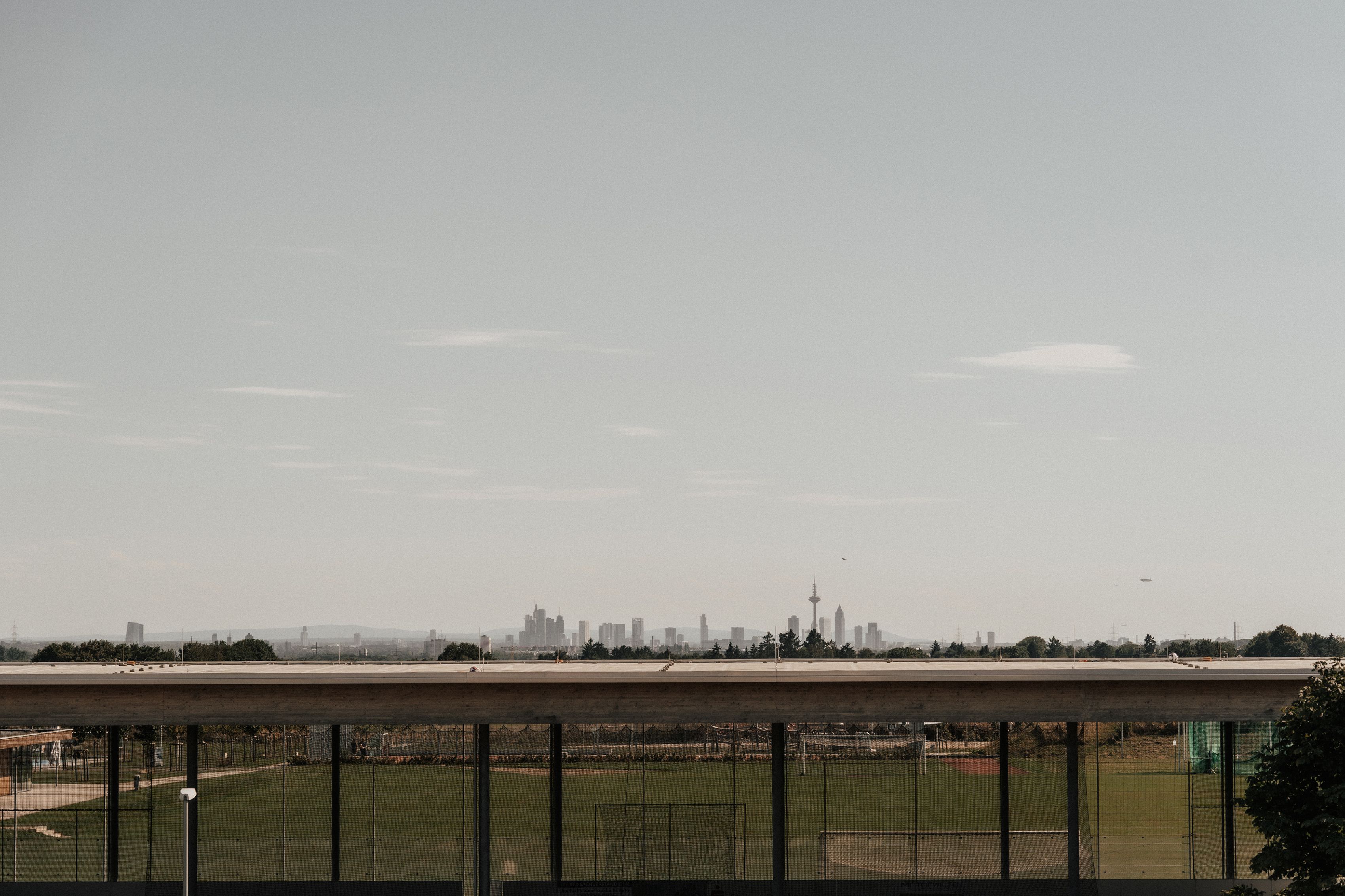Distant city skyline visible across a sweeping green valley