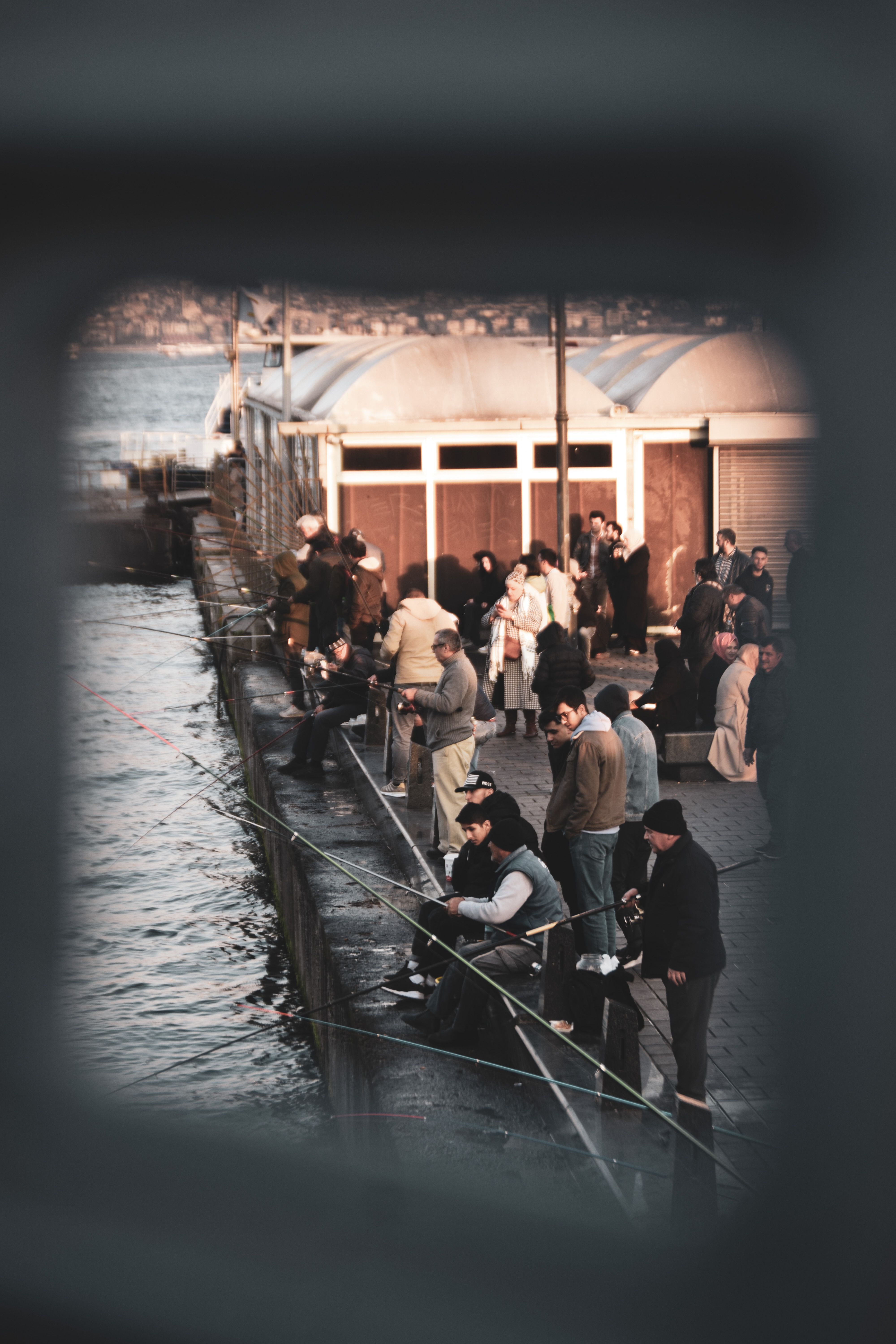 A bustling scene of people fishing along the Bosphorus in Istanbul, Turkey.