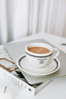 Elegant cappuccino cup on a chic desk setup, perfect for coffee lovers.