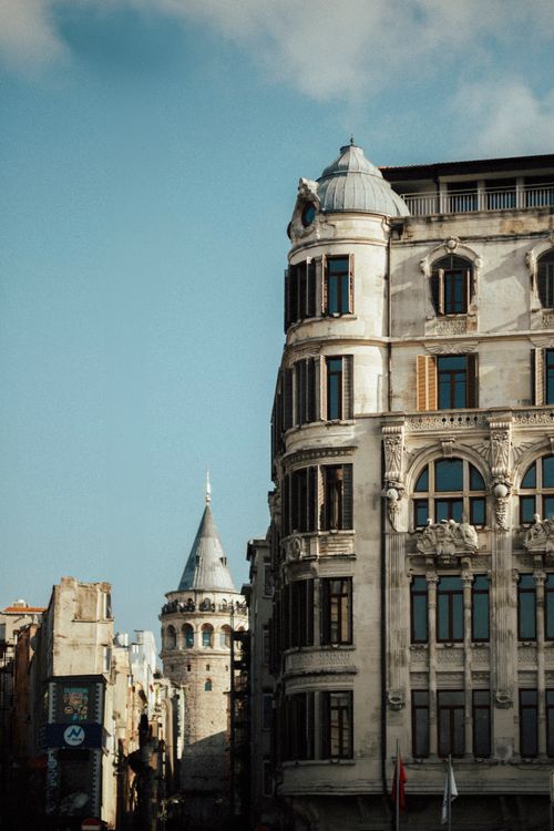 Free View of the iconic Galata Tower amidst historic architecture under a clear blue sky. Stock Photo