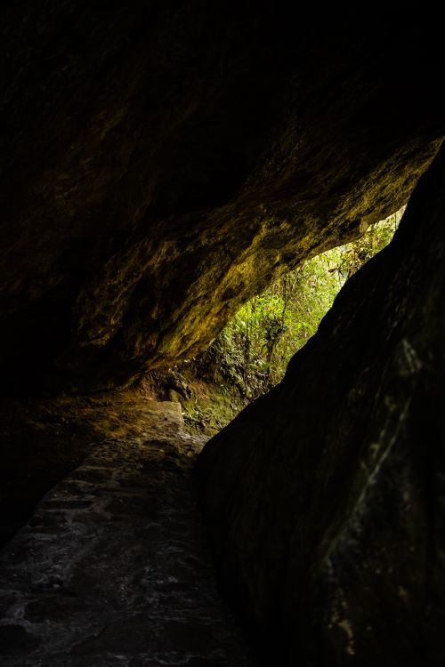 Free Explore the entrance to a dark cave leading into lush greenery. Stock Photo